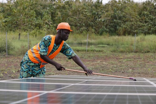 Operario limpiando paneles solares en África